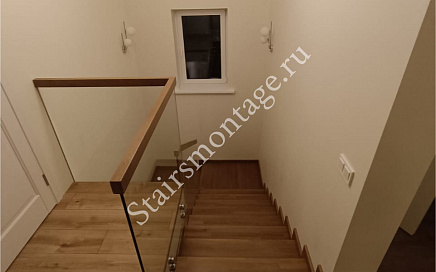 Отделка бетонной лестницы с ограждением из стекла в загородном доме в Николо-Черкизово